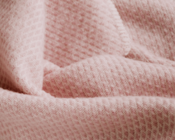 Wollen wiegendeken in een zacht roze kleur